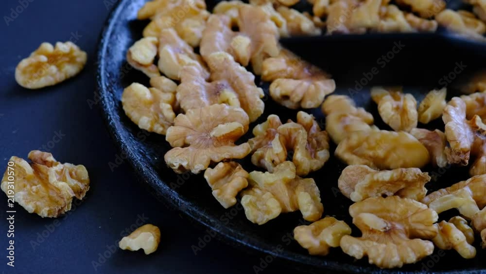 Walnut kernels on the hot pan, black background