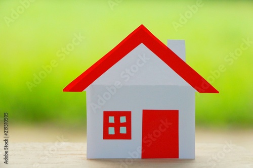 Paper cut of house red roof on green background. © jajam_e