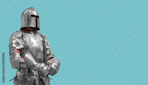Billede på lærred Medieval knight in shiny metal armor on a blue background.