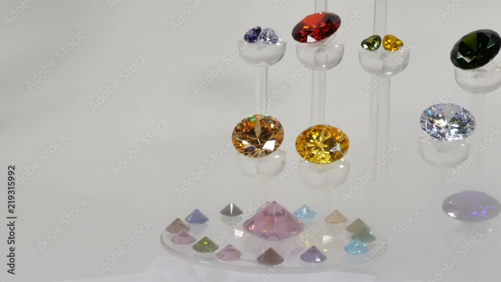 colorful diamonds on the turning podium in white smoke background. colorful diamonds on the turning podium in white smoke background.