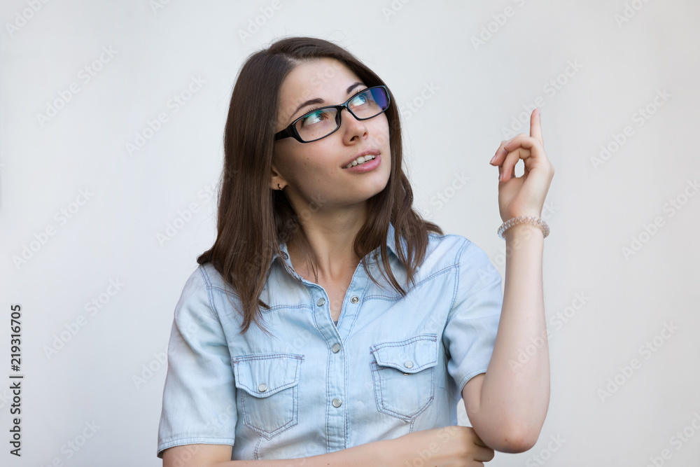 Woman in eyeglasses points finger away on white background Woman in eyeglasses points finger away on white background
