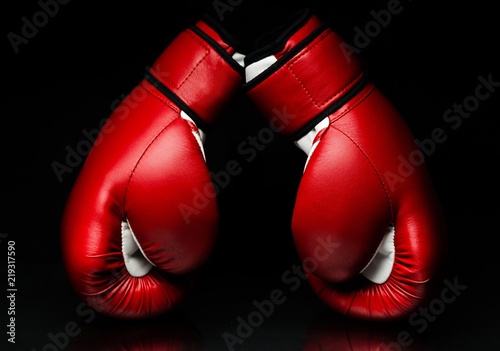 A pair of red boxing gloves,l on reflective surface © BillionPhotos.com