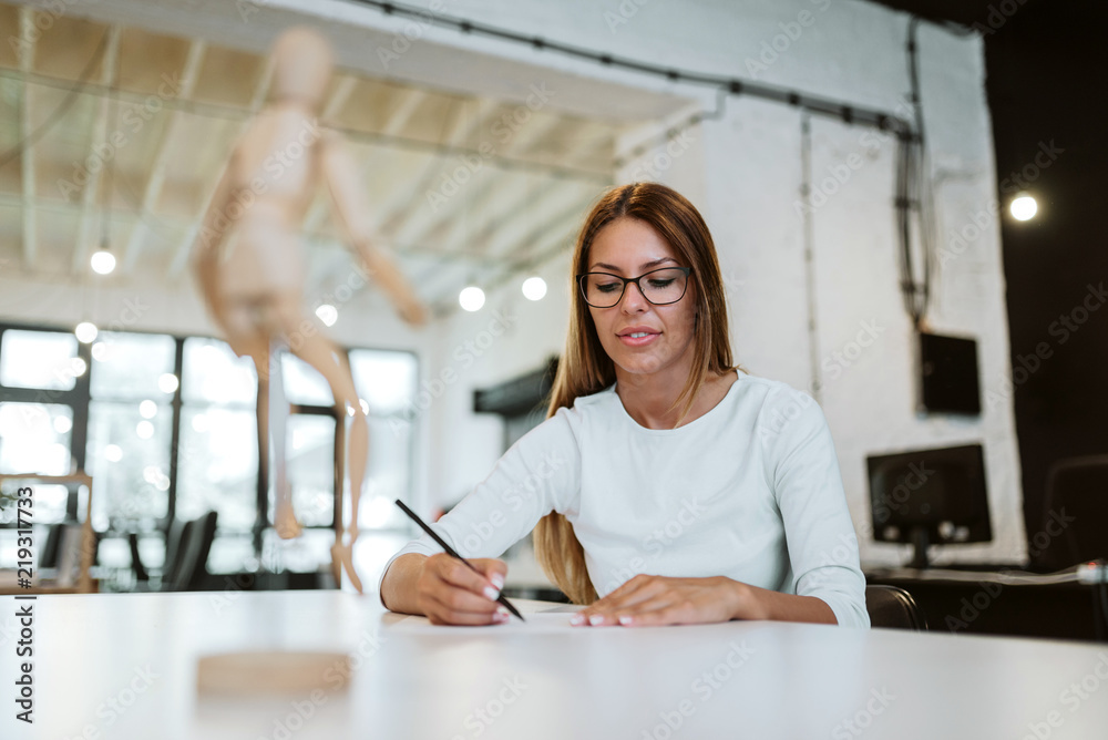 Low angle image of young woman drawing in creative studio. Low angle image of young woman drawing in creative studio.