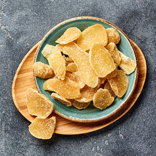 Dried sweet ginger with sugar on a gray table. Top view. photo