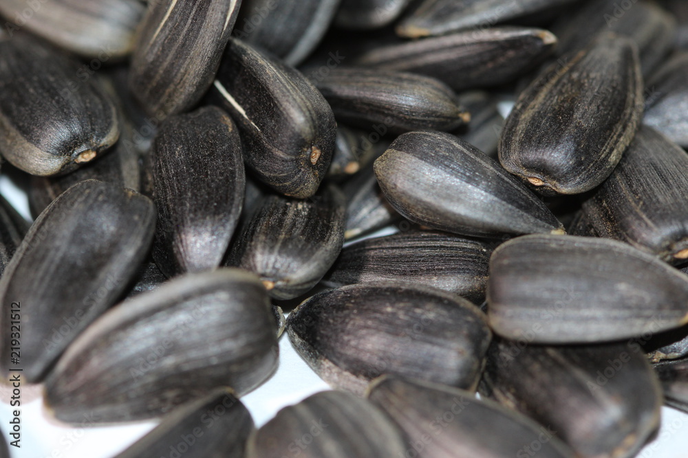 Black sunflower seeds. For texture or background. Seed sunflower. Collection of black sunflower seeds isolated on white. Pile of black sunflower seeds. Roasted seeds. Close-up of delicious sunflowers. Black sunflower seeds. For texture or background. Seed sunflower. Collection of black sunflower seeds isolated on white. Pile of black sunflower seeds. Roasted seeds. Close-up of delicious sunflowers.