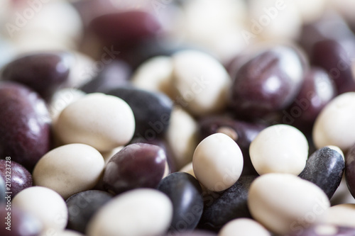Multi-colored beans on a white background. Red and white beans in a background. Assortment of dried multi-colored beans, healthy ingredient. Bright multi-colored beans. A complete source of protein.