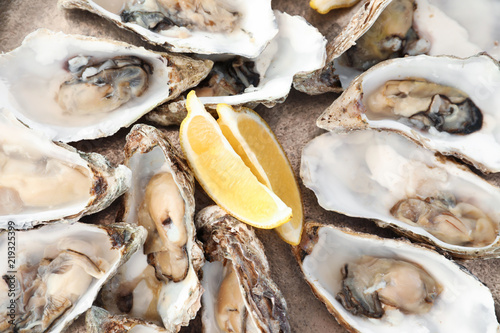 Fresh oysters with cut juicy lemon, top view