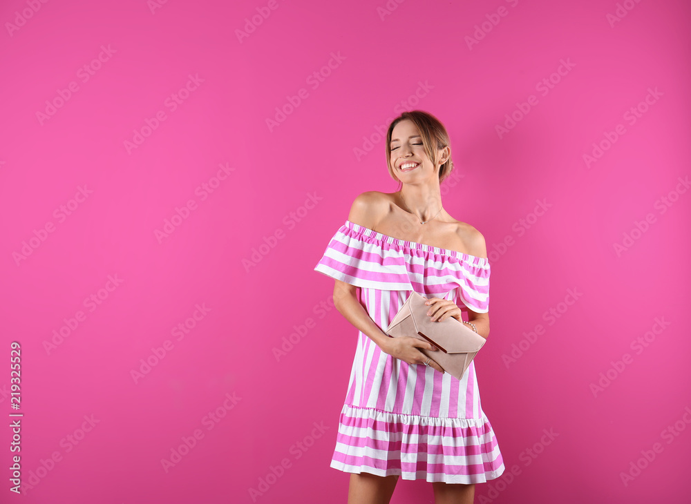 Portrait of young woman in stylish outfit with purse on color background Portrait of young woman in stylish outfit with purse on color background