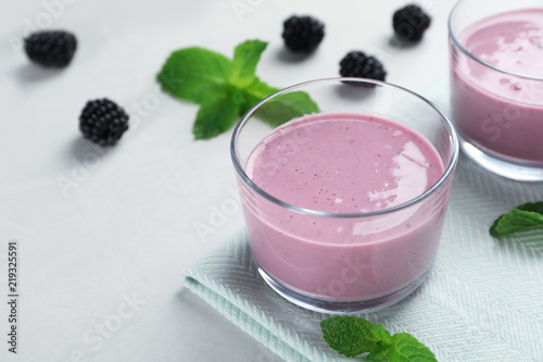 Glasses with tasty blackberry yogurt smoothies on table