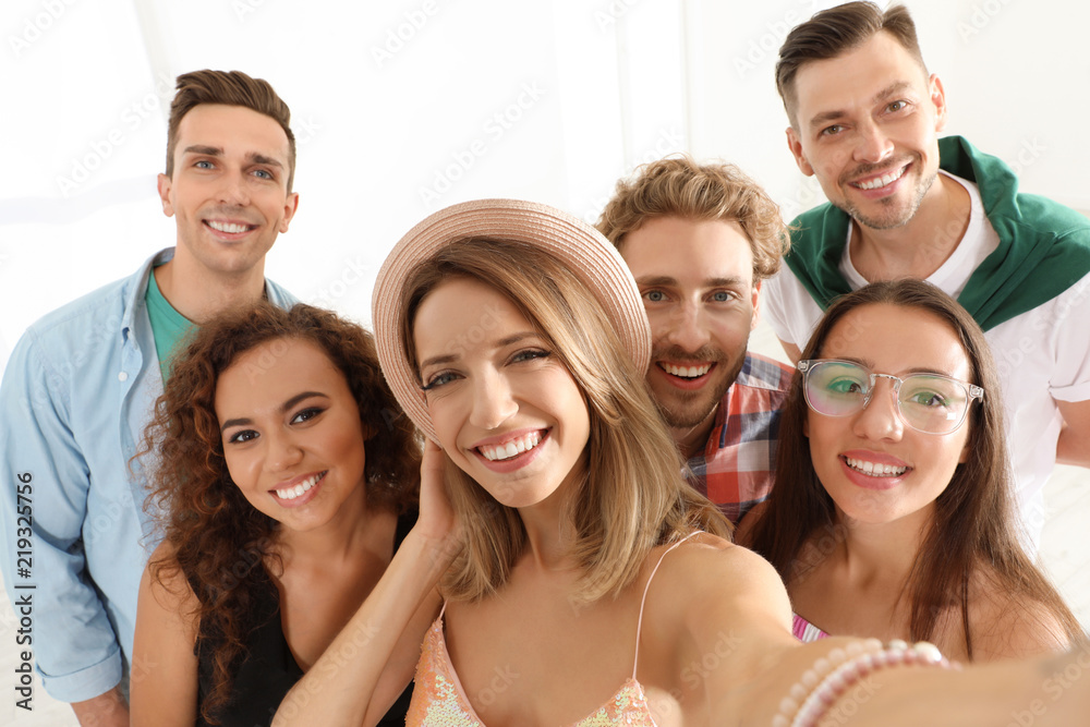 Obraz premium Grupa szczęśliwych młodych ludzi przy selfie w pomieszczeniu