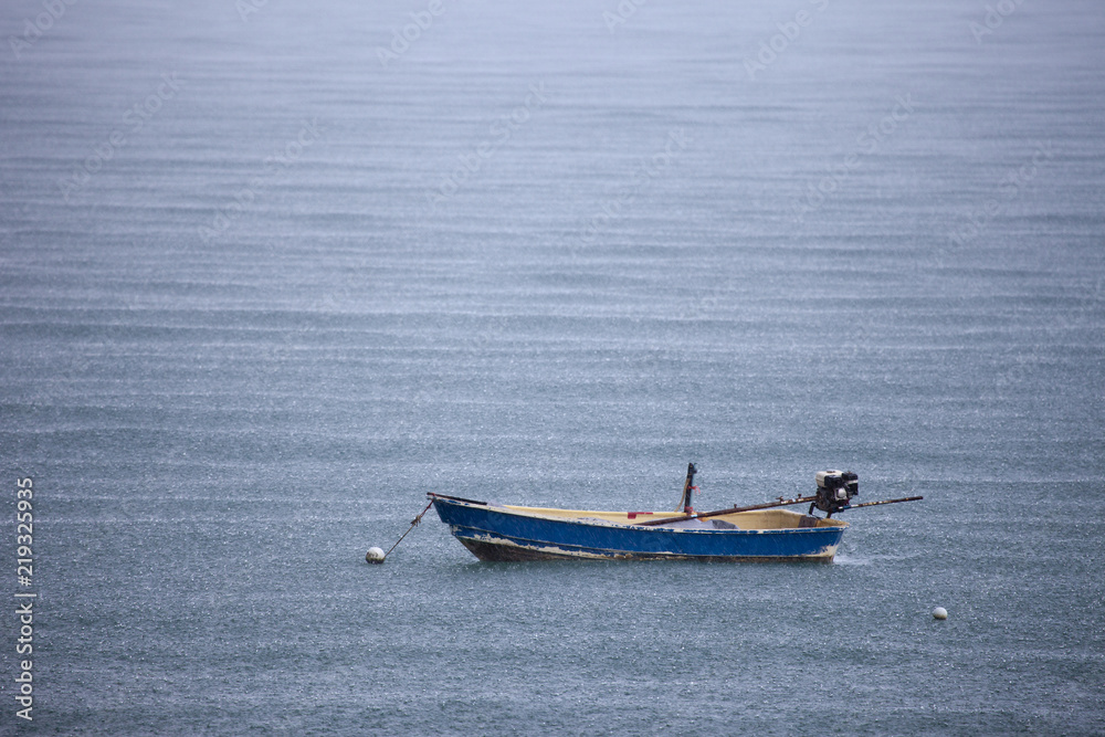 Einsames Fischerboot im Gewitterregen