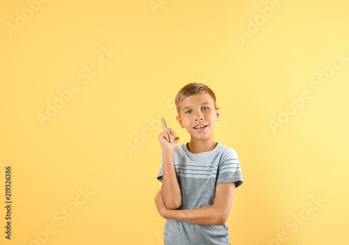 Adorable little boy in casual clothes on color background