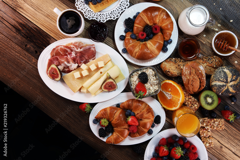 breakfast on table with waffles, croissants, coffe and juice.