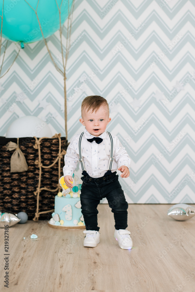 Naklejka premium Baby's first birthday. Cute smiling baby is 1 year old. The concept of a children's party with balloons