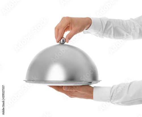 Waiter holding metal tray with lid on white background, closeup photo