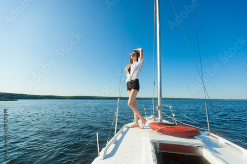 Girl standing on the bow of a sailboat, boat. Copy space