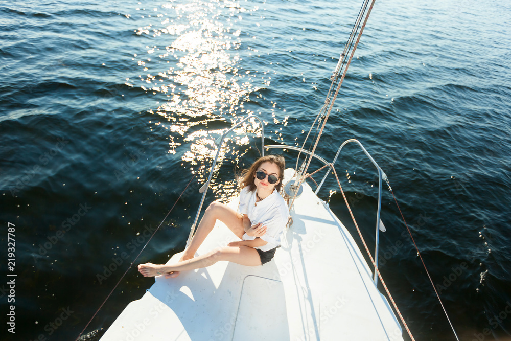 Girl in sunglasses resting on a yacht, sailboat