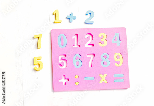 The child is studying the numbers and the account. Arranges the colored blocks to the desired numbers. Mathematics for children. photo