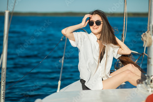 Girl sitting on the bow of a sailboat, ship