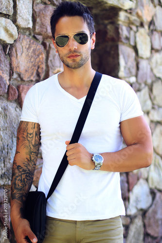 Fashionable man wearing satchel bag, watch ans sunglasses . Summer clothes for men