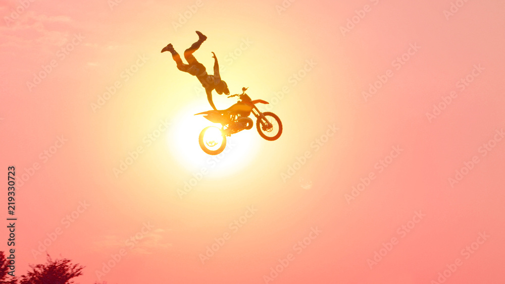 Fototapeta premium Extreme pro motocross biker jumping freestyle trick over the sun