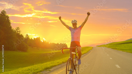 LENS FLARE: Caucasian rider celebrates finishing bike tour through countryside