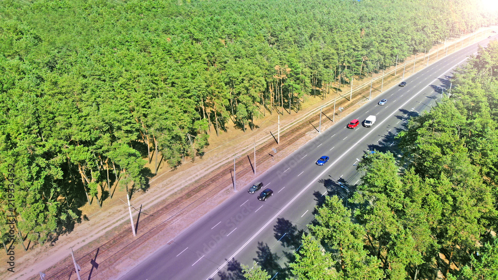 Naklejka premium Aerial photo of a highway traffic between city greenery
