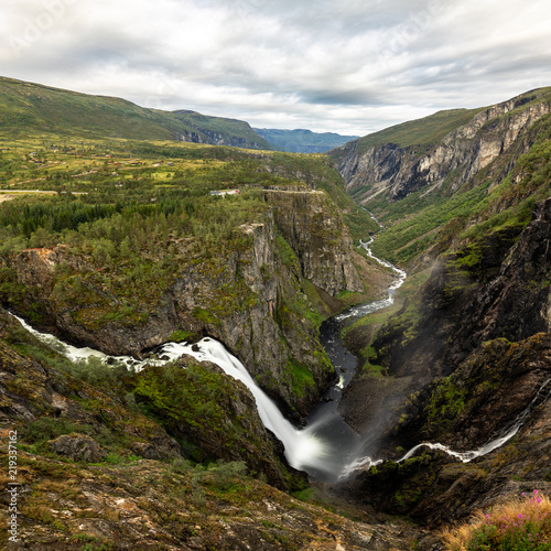 Beautiful view of the Voringsfossen waterfall. Bjoreio river . National park Hardangervidda, Eidfjord, Norway. Summer landscape in the mountains with a waterfall and fog. Foggy weather in the mountain photo