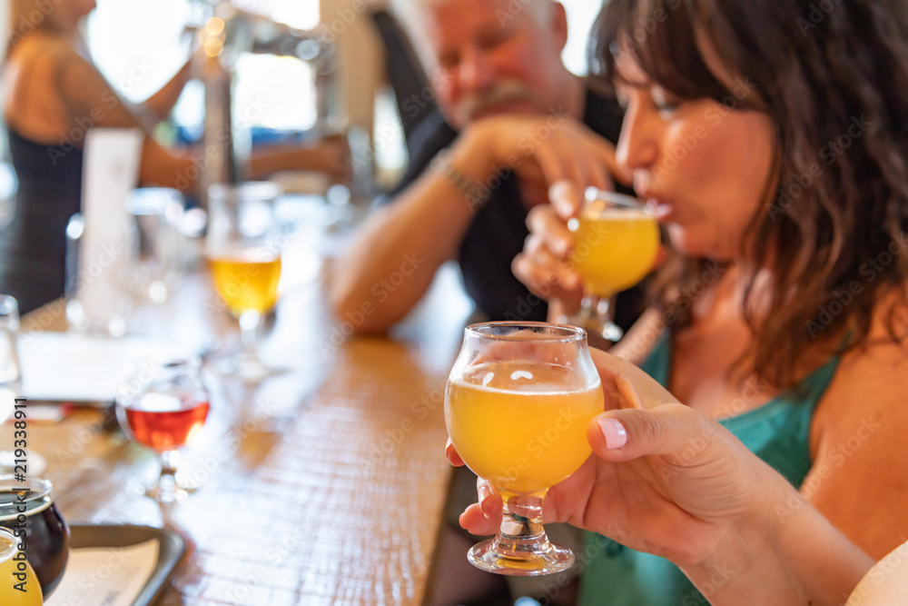 Group of Friends Enjoying Glasses of Micro Brew Beer At Bar Group of Friends Enjoying Glasses of Micro Brew Beer At Bar