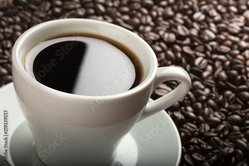 Closeup of cup of coffee and coffee beans