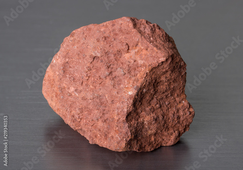 Specimen of mineral stone bauxite on gray background. Bauxite ore is the main source of aluminium.  photo