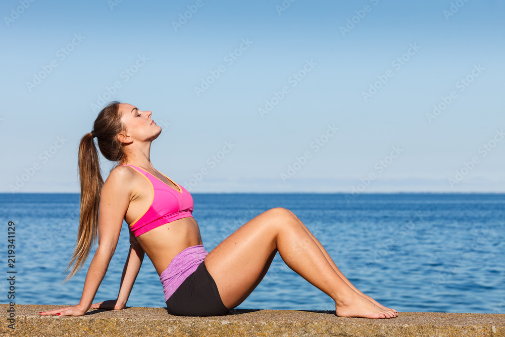 Woman doing sports exercises outdoors by seaside Woman doing sports exercises outdoors by seaside