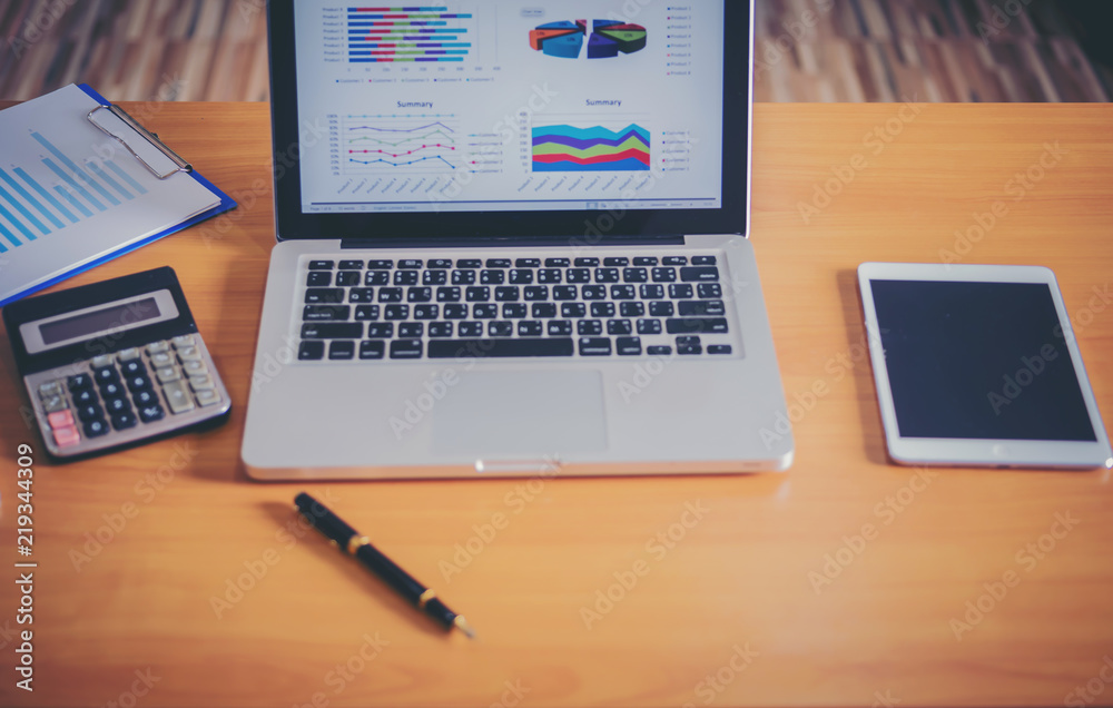 Laptop with financial documents on wooden table Laptop with financial documents on wooden table