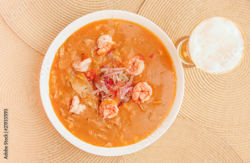 Above view of Ecuadorian food: shrimp cebiche with a glass of beer in wooden table background