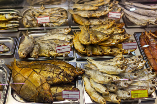 various types of smoked fish in a supermarket on a glass refrigerator