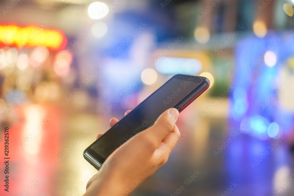 Woman hand using smartphone in mall