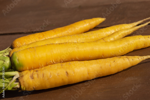 A bunch of clean fresh carrots on a wooden background