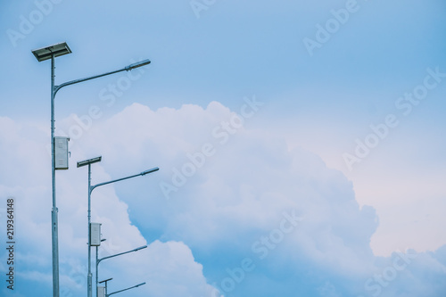 Public Electricity light power from slor cell with summer blue sky, white cloud and light flare from sun abstract background. photo