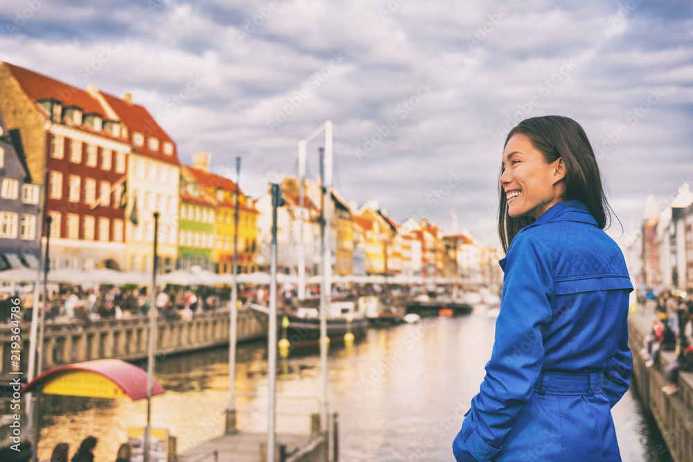 Obraz Tourist in Copenhagen. Chinese Asian woman traveler walking in Nyhavn visiting Denmark. City travel, tourism in Scandinavia.