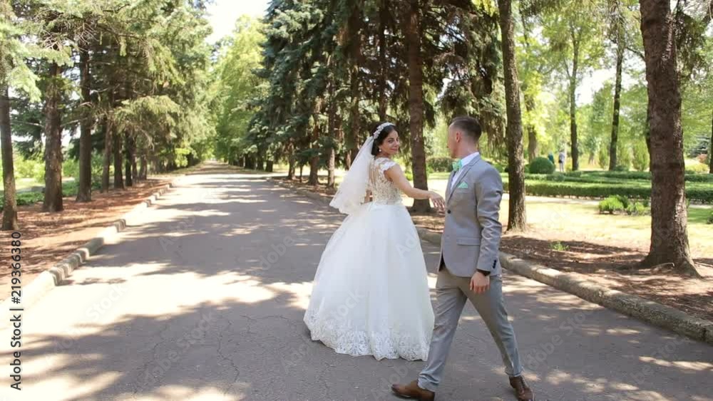 Romantic newly married couple dancing waltz in the park on their wedding day. Romantic newly married couple dancing waltz in the park on their wedding day.