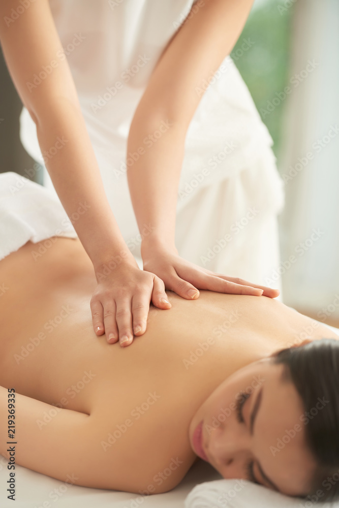 Young Asian woman enjoying back massage in spa salon Young Asian woman enjoying back massage in spa salon
