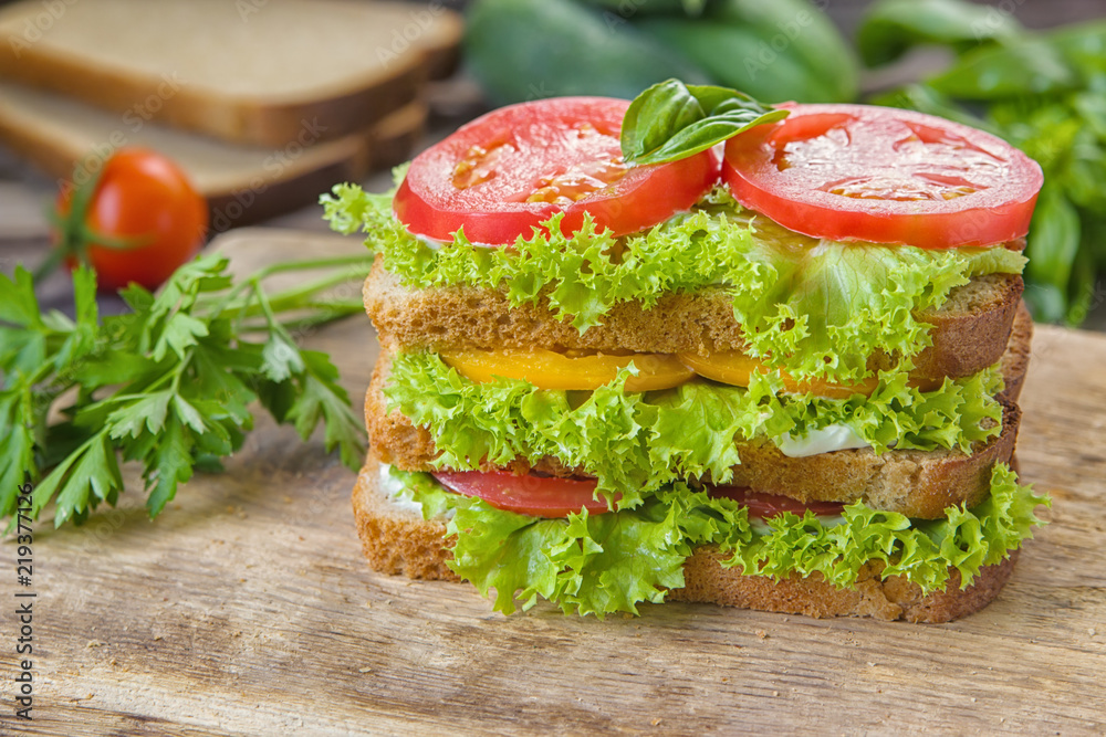 Sandwich with fresh tomato, lettuce and cream cheese