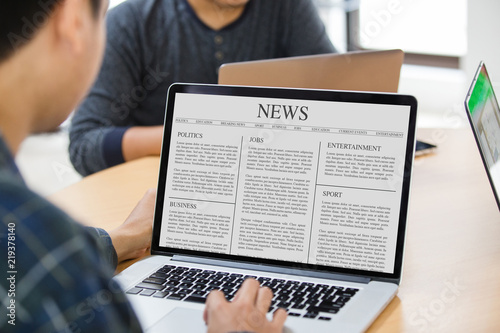Man reading news article on the laptop screen at office