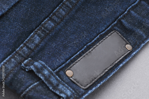 part of denim pants with back pockets and label, close-up
