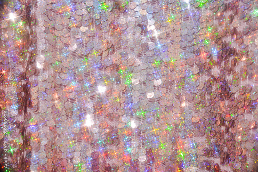 Sequins close-up macro. Abstract background with sequins colorful on the fabric. Texture scales of round sequins 