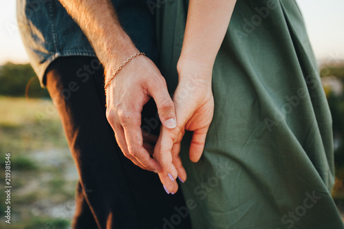 Hands of a young couple. Gentle touch, romantic moment. Close-up. photo