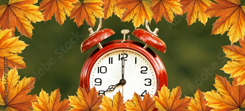 Daylight savings time, autumn - red alarm clock with orange leaves border - web banner idea