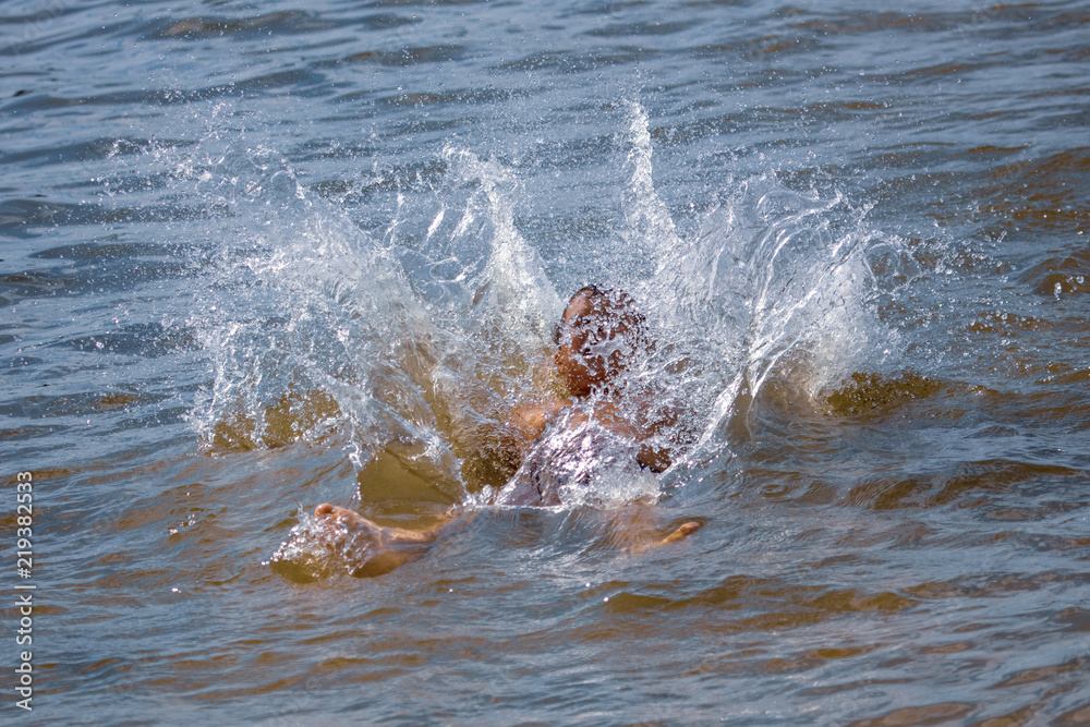 Obraz premium The boy is swimming on the beach