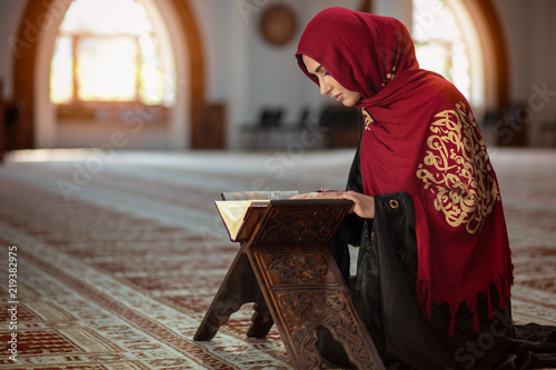 Photography Young muslim woman praying in mosque with quran