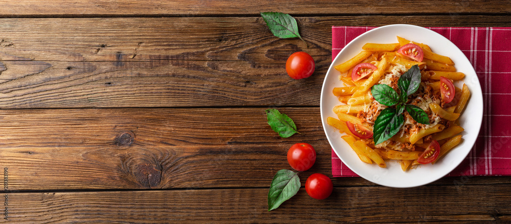 Pasta bolognese with tomato sauce and minced meat, grated parmesan cheese and fresh basil - homemade healthy italian pasta on rustic wooden background. Flat lay. Top view. Pasta bolognese with tomato sauce and minced meat, grated parmesan cheese and fresh basil - homemade healthy italian pasta on rustic wooden background. Flat lay. Top view.